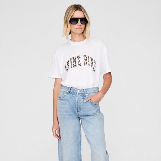 Woman wearing a white t-shirt with text and light blue jeans on a white background