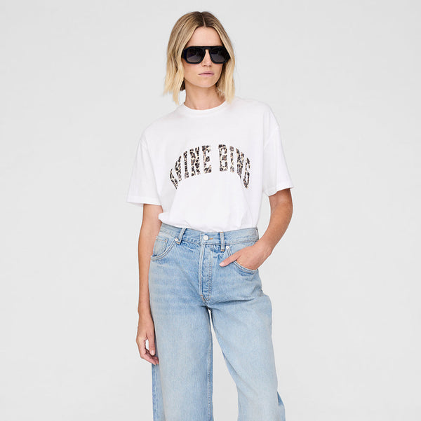 Woman wearing a white t-shirt with text and light blue jeans on a white background