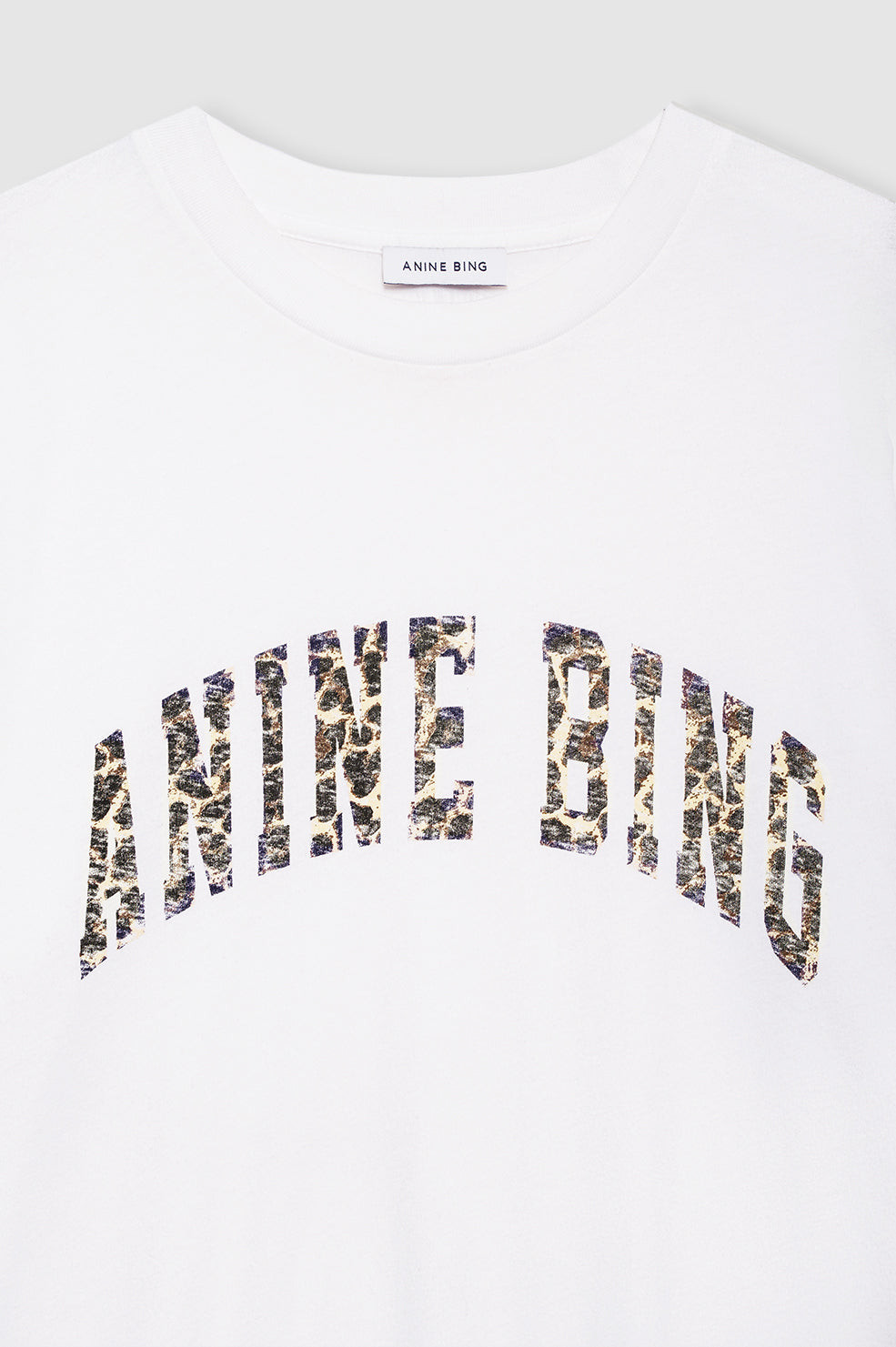 White t-shirt with 'Manne Bing' printed in black and gold on a white background