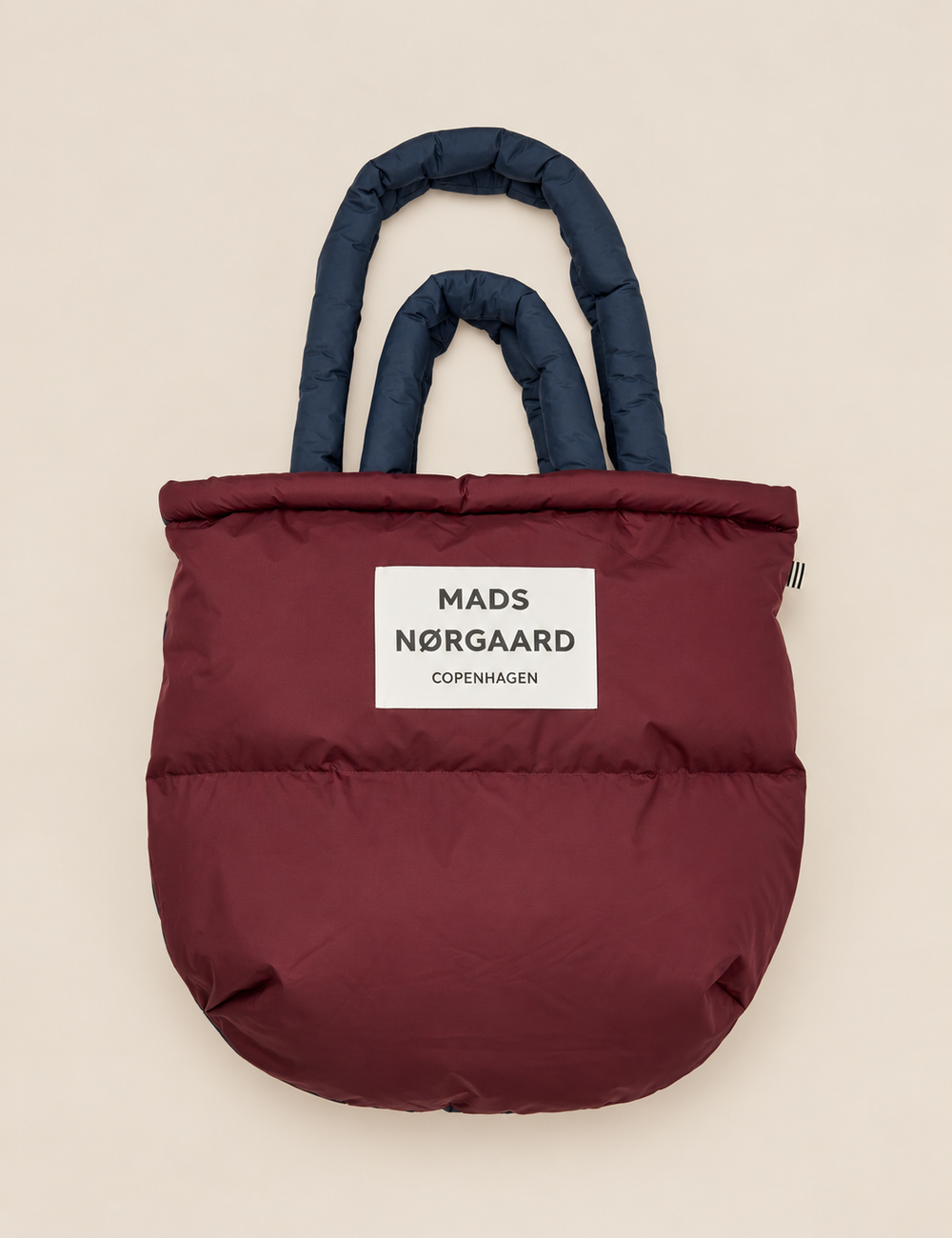 Mads Nørgaard Light Ripstop Pillow Bag in Sky Captain/Winetasting, a lightweight oversized puffer tote bag with dual padded handles and recycled polyester construction.