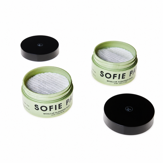 Three open round jars of Sofie Paris micellar cleansing lotion with white cotton pads inside, arranged on a clean white background with two black lids placed nearby.