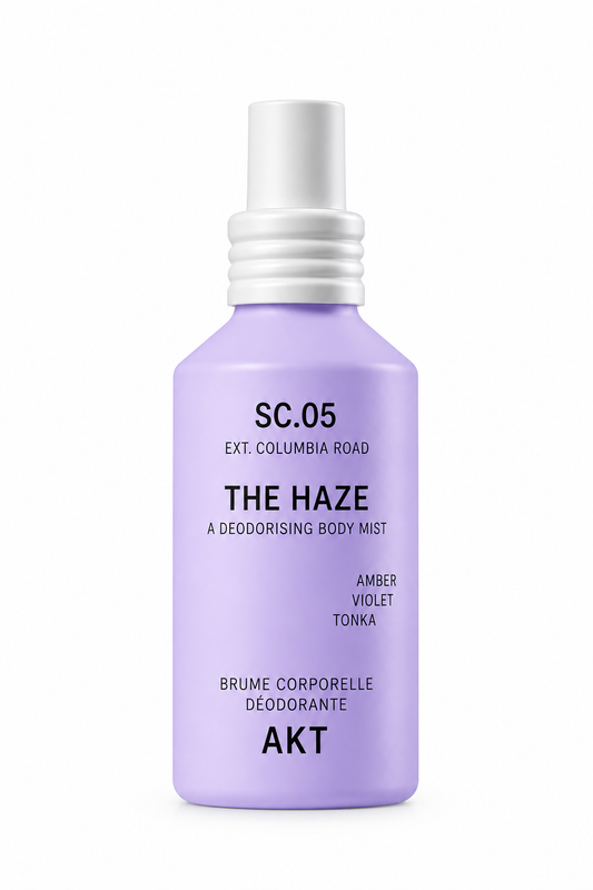 A lavender purple spray bottle of 'The Haze' deodorising body mist by Akt, featuring a white spray nozzle and black text on a clean white background.