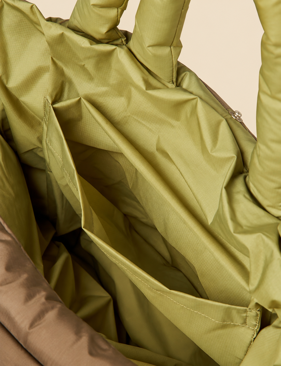 Interior detail of the Mads Nørgaard Green Olive/Tarmac Pillow Bag showing the fabric lining and inside pocket.